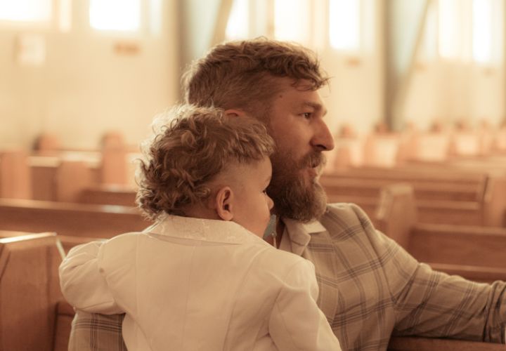 Un père et son très jeune fils sont assis dans une église.